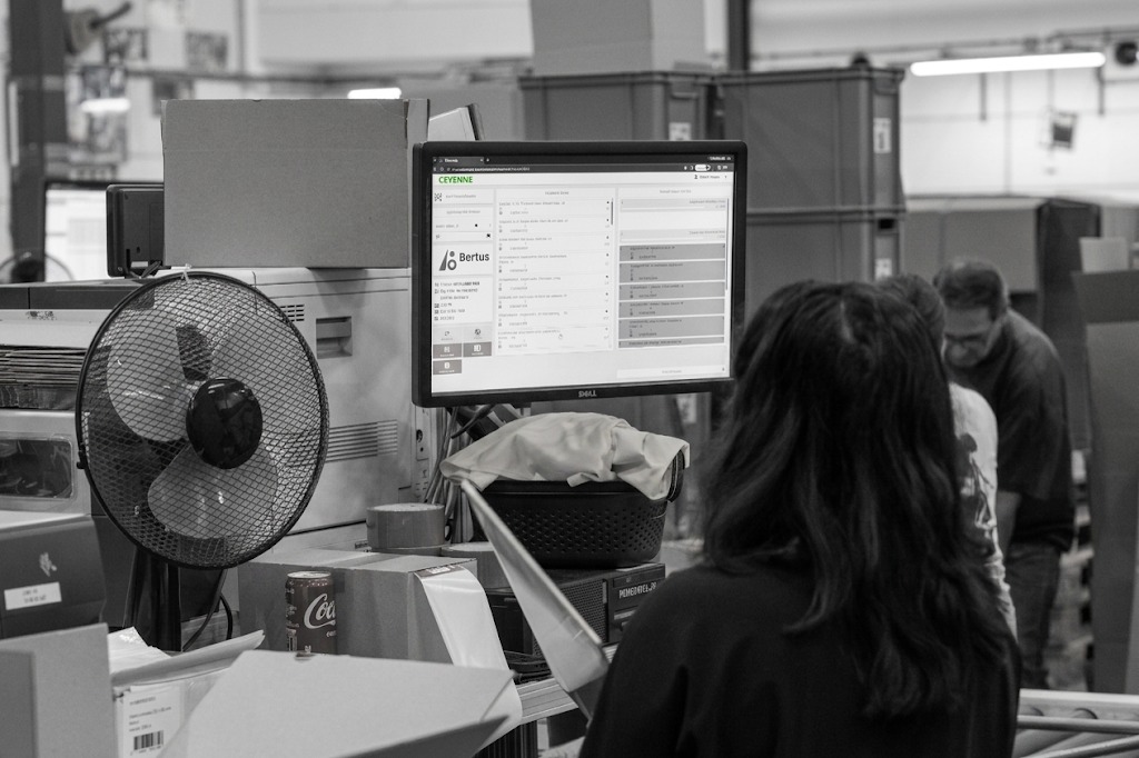 Een medewerker werkt bij het WMS-werkstation in het magazijn van Bertus.