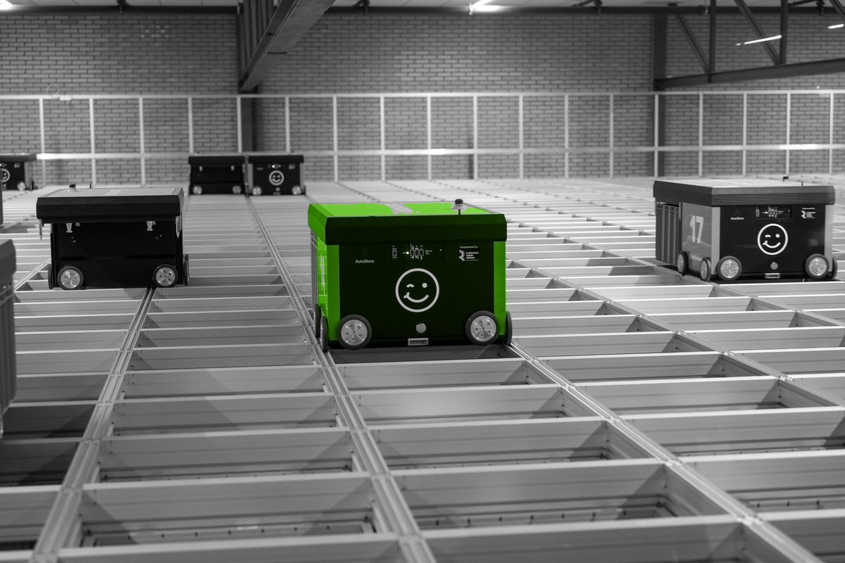 Autonome magazijnrobots bewegen over een rastervloer.