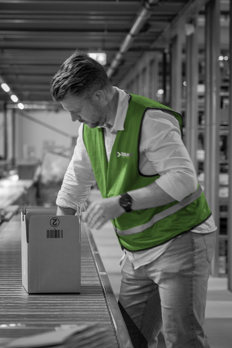 Een consultant verwerkt een doos in het magazijn.