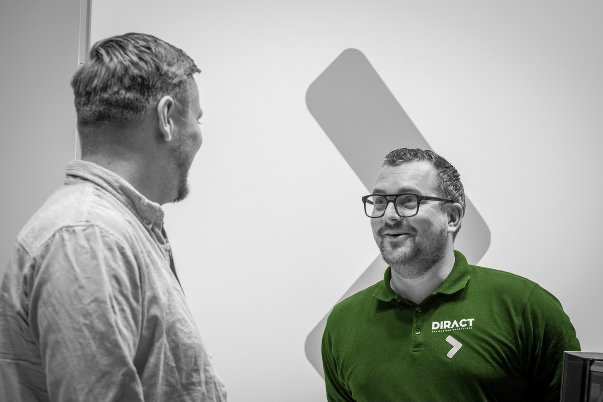 Een Diract-medewerker is in gesprek met een bezoeker.