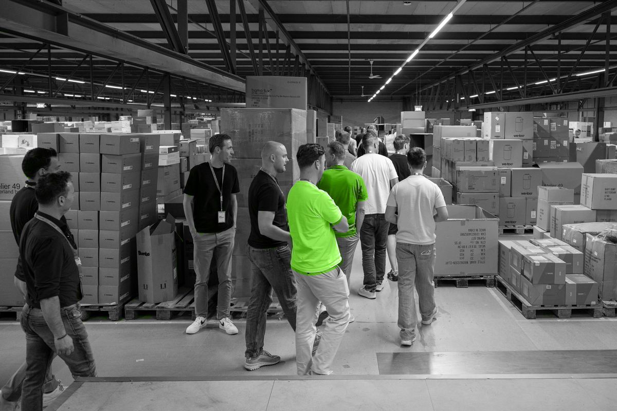 Een groep deelnemers tijdens een rondleiding door het magazijn.