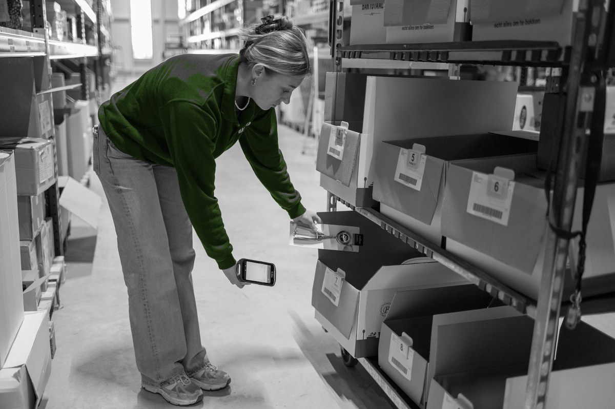 Een magazijnmedewerker verzamelt artikelen met behulp van een handterminal.