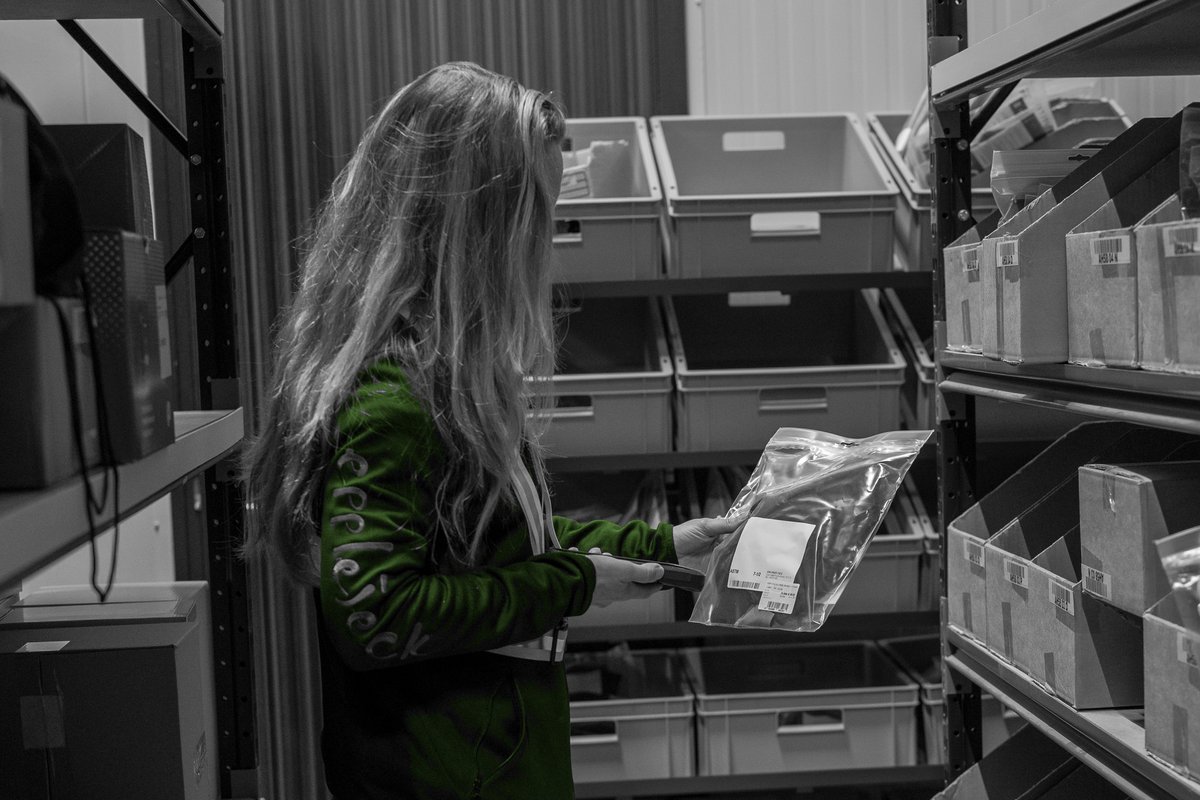 Een medewerker verzamelt een verpakt artikel in het magazijn.