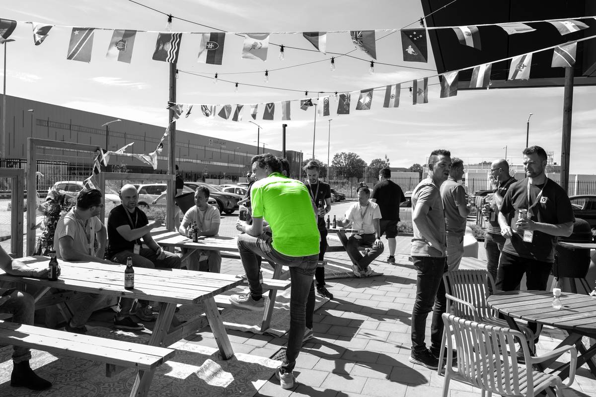 Deelnemers praten met elkaar tijdens een netwerkborrel op een terras.