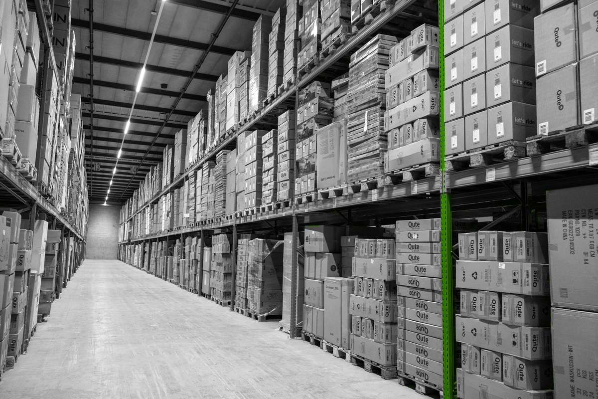 Brede magazijngang met palletstellingen en ruimte voor goederenverplaatsing.